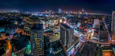 Nighttime cityscape of Manila, Philippines, showcasing illuminated buildings and vibrant urban lights in a 4K Ultra HD city skyline view.