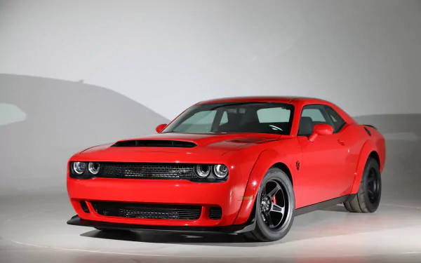 Red Dodge Challenger SRT Demon muscle car in a studio shot, HD PC desktop wallpaper/background showcasing its aggressive front end and wide stance.