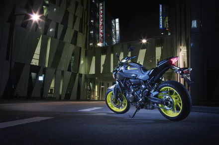 Yamaha MT-07 motorcycle with neon yellow wheels parked in a modern urban setting at night, captured in 4K Ultra HD for a striking desktop wallpaper.