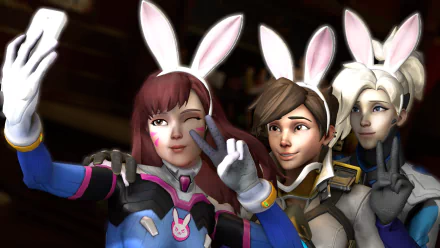HD PC desktop wallpaper of Overwatch video game heroes D.Va, Tracer, and Mercy wearing bunny ears and posing together for a playful selfie.