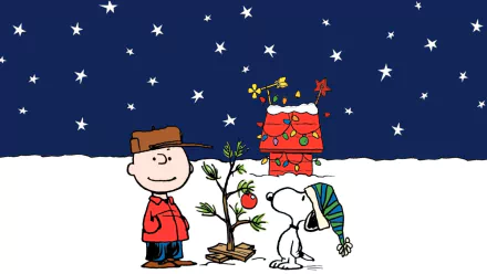 Charlie Brown and Snoopy stand by a small, decorated Christmas tree against a starry night backdrop, with Snoopy's festive red doghouse in the background. From the movie A Charlie Brown Christmas. HD wallpaper.