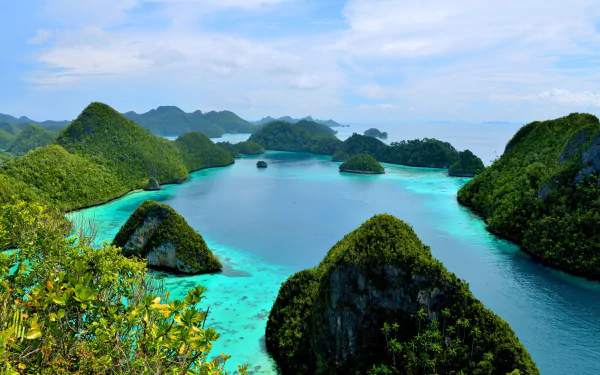 HD PC desktop wallpaper background: tropical lagoon of turquoise water dotted with small green islands under a blue horizon sky, lush nature panorama.