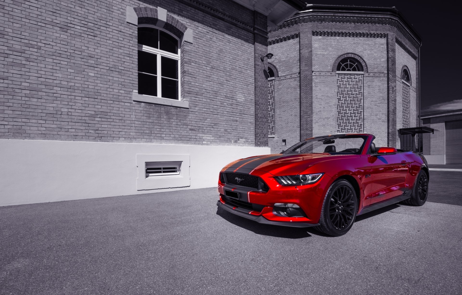 A red Ford Mustang GT muscle car parked near a brick building, showcased as a 4K Ultra HD PC desktop wallpaper and background.