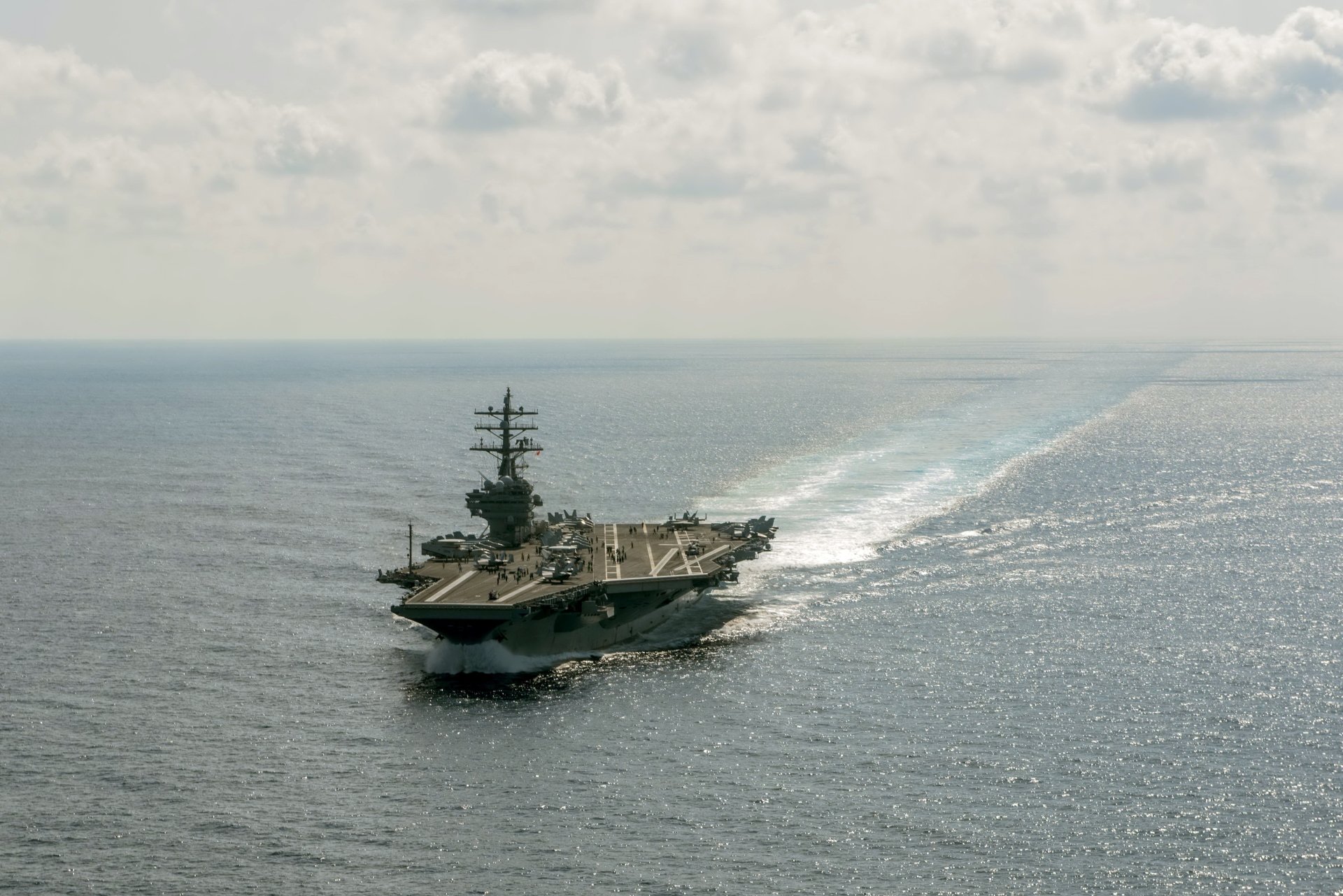 4K Ultra HD desktop wallpaper of the U.S. Navy aircraft carrier USS Ronald Reagan (CVN-76) steaming at sea, flight deck and wake visible.