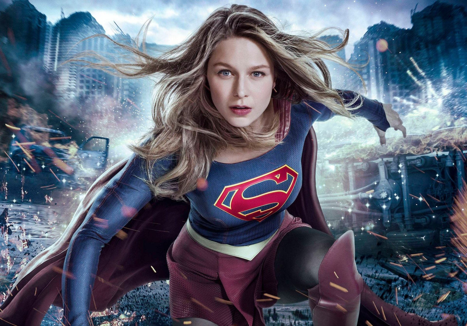 HD desktop wallpaper featuring Melissa Benoist as Supergirl in action from the TV show Supergirl, with a dramatic, cityscape background.