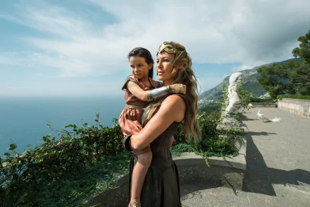 General Antiope (Robin Wright) holds a young girl against a scenic coastal backdrop in a HD desktop wallpaper from the movie Wonder Woman.