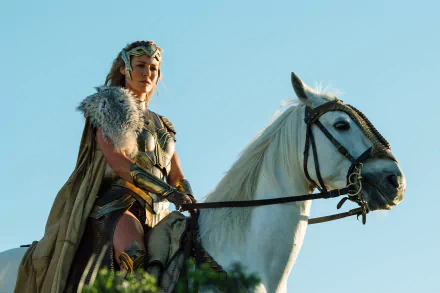 HD wallpaper featuring General Antiope, portrayed by Robin Wright, on horseback in the movie Wonder Woman. The scene captures her in warrior attire, set against a clear blue sky.