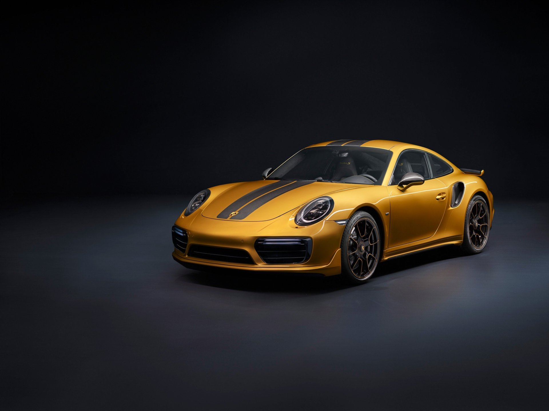 HD wallpaper of a sleek yellow Porsche 911 Turbo sports car displayed against a dark background, highlighting its dynamic design and vibrant color.