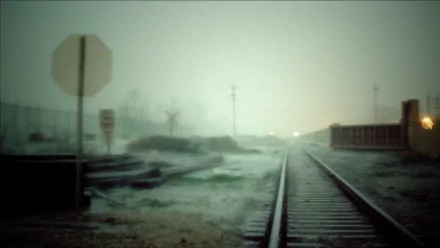 A moody, atmospheric image of a railyard at dusk, featuring blurred railroad tracks fading into the mist, creating a hauntingly beautiful desktop wallpaper.