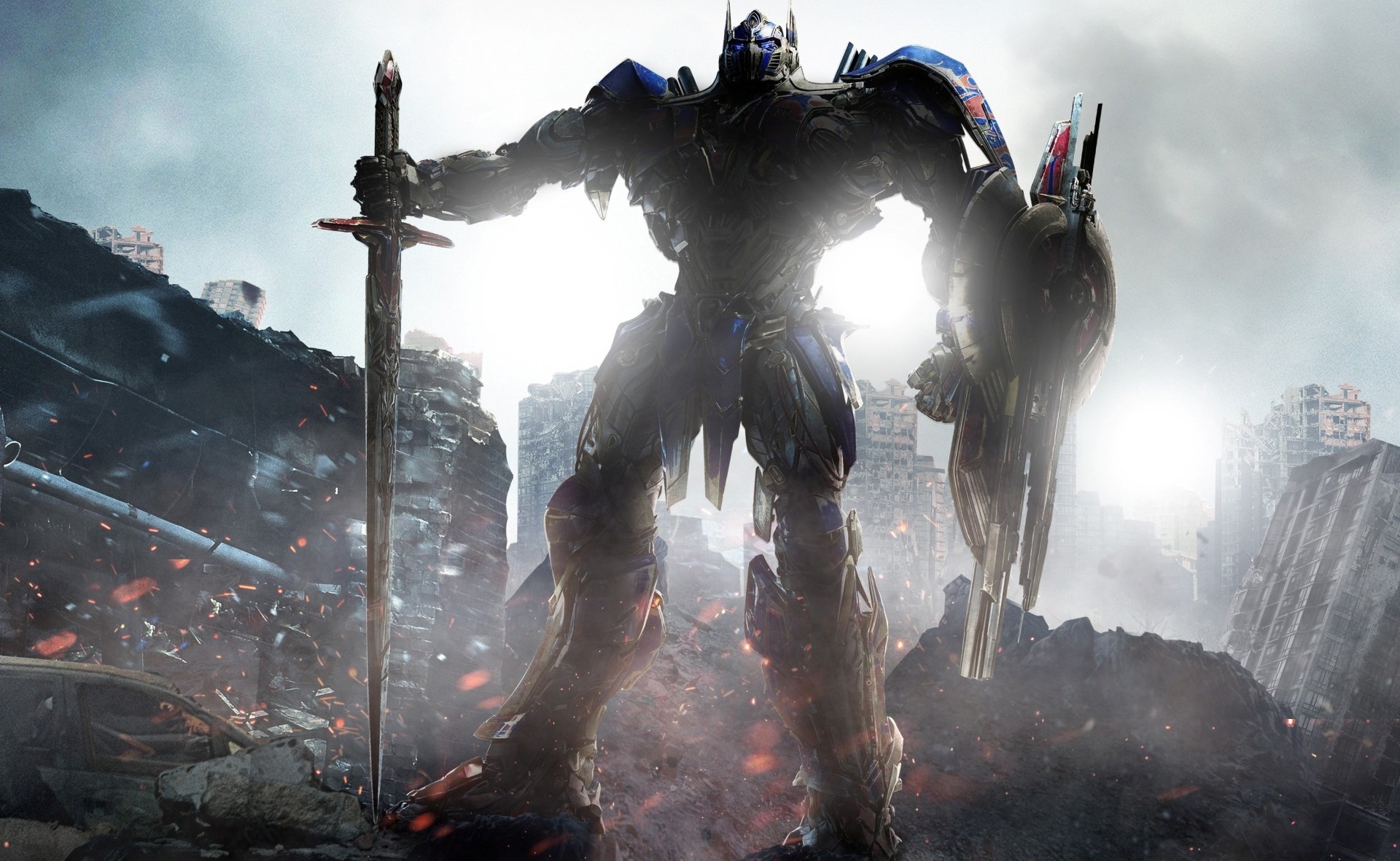 HD desktop wallpaper featuring Optimus Prime from Transformers: The Last Knight, holding a sword and shield amidst a dramatic, battle-torn landscape.