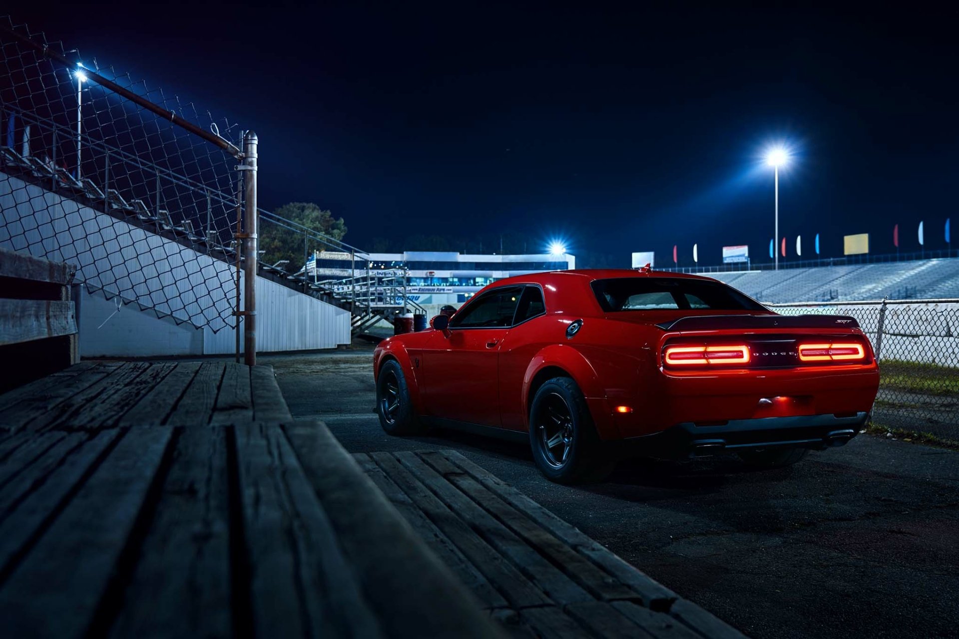 Red Dodge Challenger SRT Demon muscle car (Mopar) parked on a dim racetrack at night, HD PC desktop wallpaper and background.