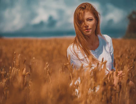 A redhead woman stands in a sunlit wheat field with a soft depth of field, captured in a serene summer scene for an HD desktop wallpaper.