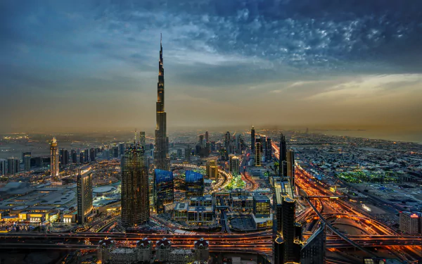 A stunning HD wallpaper of Dubai's cityscape featuring illuminated skyscrapers, including the iconic Burj Khalifa, against a twilight horizon in the United Arab Emirates.