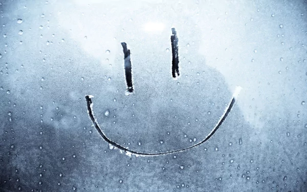 A whimsical smiley face drawn on a foggy glass surface, surrounded by droplets, serves as a charming and humorous HD desktop wallpaper and background.