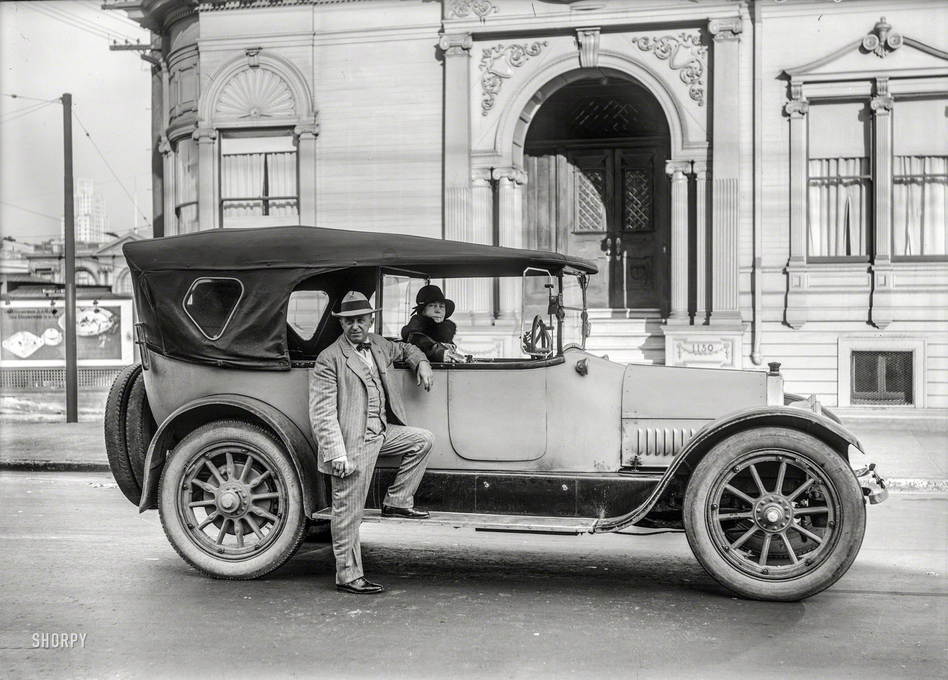 Black-and-white vintage photograph showcasing a classic car parked in front of an ornate building, designed as an HD PC desktop wallpaper and background.