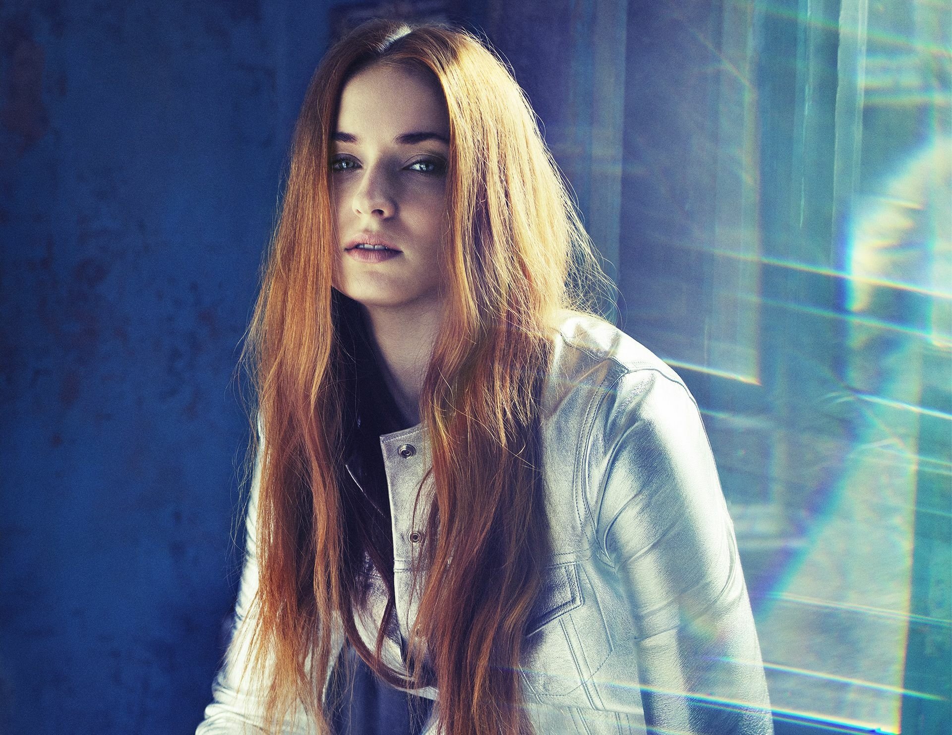 HD desktop wallpaper featuring a close-up portrait of Sophie Turner, an American actress with red hair and striking blue eyes.