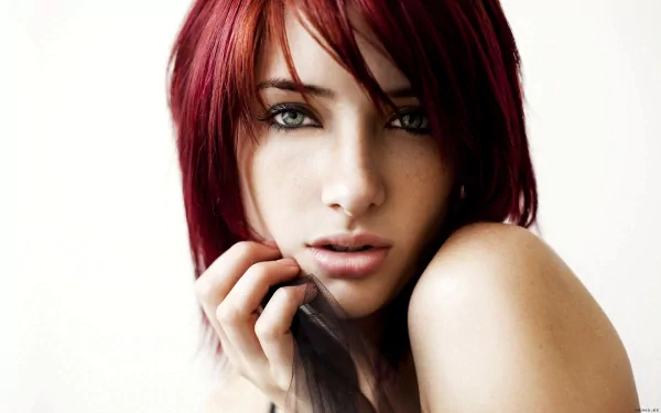 HD desktop wallpaper featuring celebrity Susan Coffey with red hair, gazing intently at the camera against a light background.
