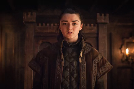 HD desktop wallpaper featuring actress Maisie Williams as Arya Stark from the TV show Game of Thrones, set against a medieval wooden interior.