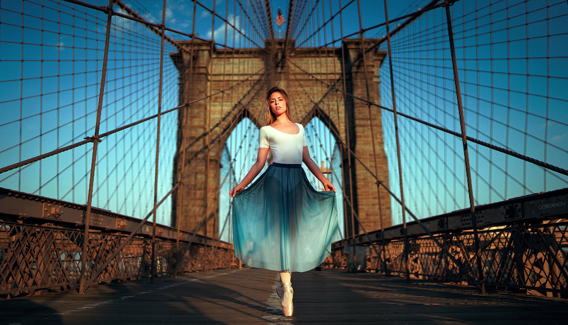 Ballerina model woman in pointe shoes wearing a flowing blue skirt posed on the Brooklyn Bridge at sunrise — HD PC desktop wallpaper background