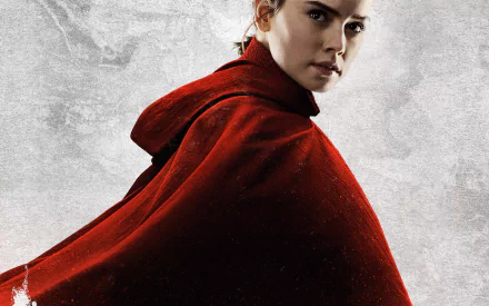 HD desktop wallpaper featuring Daisy Ridley as Rey from Star Wars: The Last Jedi, dressed in a red cloak, against a textured gray background.