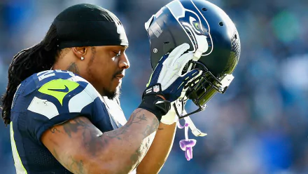 HD desktop wallpaper featuring Marshawn Lynch of the Seattle Seahawks holding his helmet.