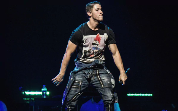 HD wallpaper featuring Nick Jonas performing on stage, showcasing his dynamic energy and style in a lively concert setting.