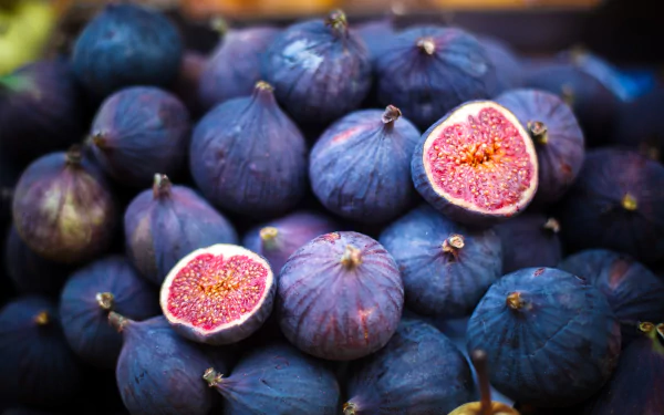 HD PC desktop wallpaper and background: close-up of ripe purple figs, two halved to reveal pink seedy flesh — fruit food image.
