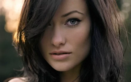 HD desktop wallpaper featuring a close-up of Olivia Wilde, with soft lighting highlighting her face and natural background.