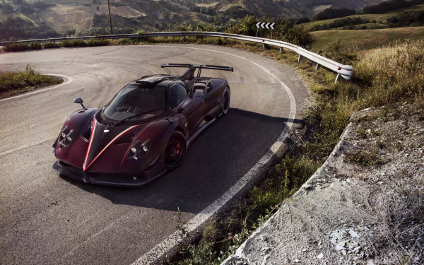 A sleek Pagani Zonda supercar parked on a winding mountain road, captured in stunning 4K Ultra HD for a dynamic PC desktop wallpaper and background.