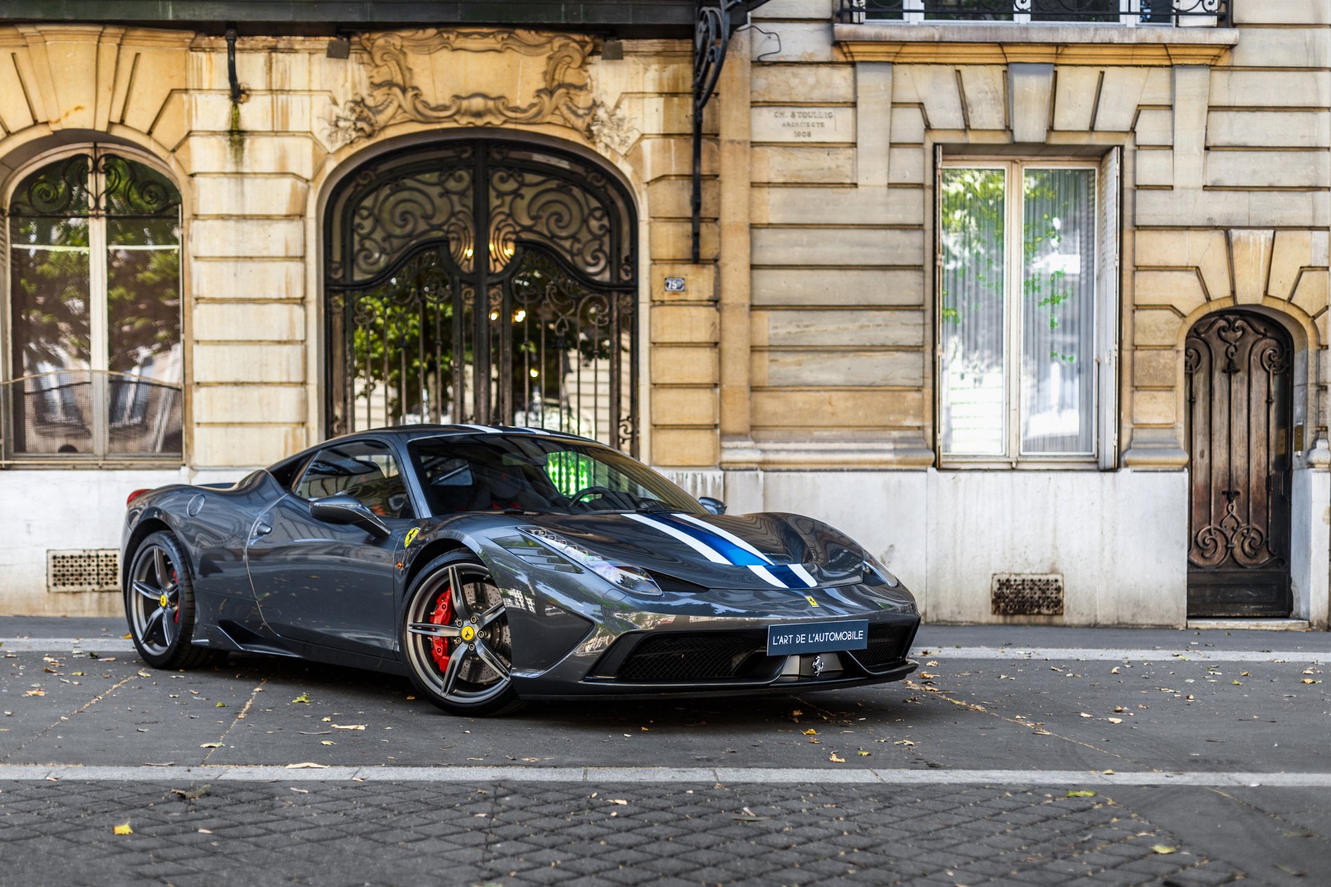HD desktop wallpaper featuring a sleek black Ferrari 458 supercar parked on a city street in front of a classic building.