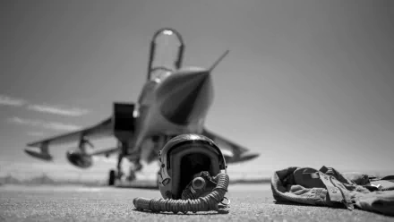 Black and white image with shallow depth of field featuring a military helmet and gear in front of a Panavia Tornado jet, captured as an HD PC desktop wallpaper.
