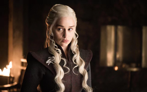 HD desktop wallpaper featuring Emilia Clarke as Daenerys Targaryen from the TV show Game of Thrones. She is gazing intently with her signature platinum-blonde hair and a dark outfit, against a dimly lit background.