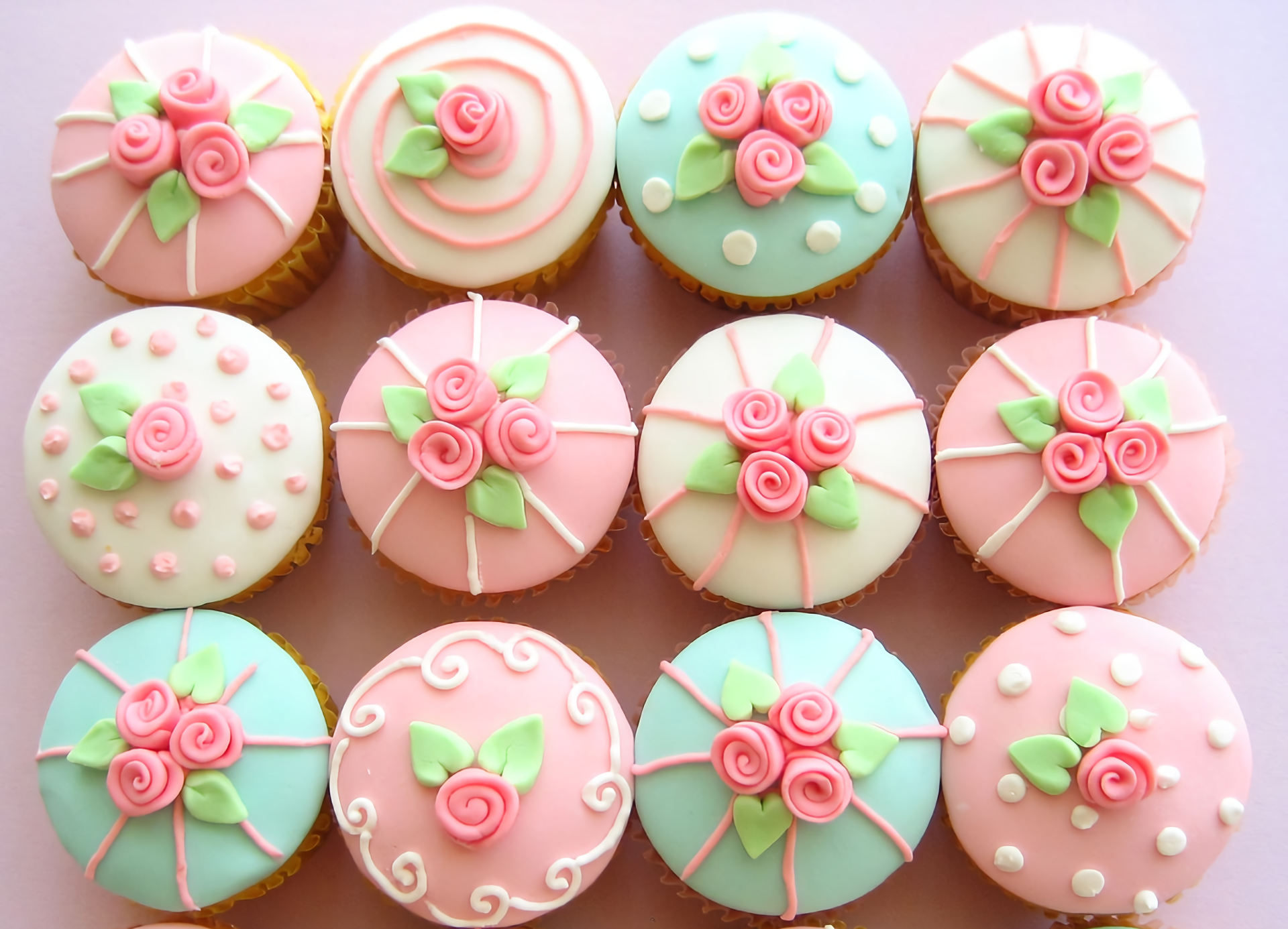 HD desktop wallpaper featuring cupcakes decorated with pink and pastel icing flowers, creating a delicate and colorful food-themed background.