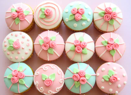 HD desktop wallpaper featuring cupcakes decorated with pink and pastel icing flowers, creating a delicate and colorful food-themed background.