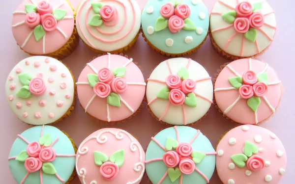 HD desktop wallpaper featuring cupcakes decorated with pink and pastel icing flowers, creating a delicate and colorful food-themed background.