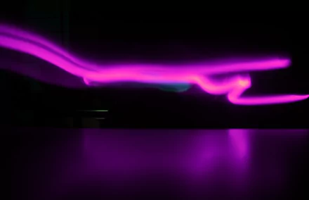 Abstract purple neon light streaks across a dark night scene, reflected below; 4K Ultra HD PC desktop wallpaper/background.