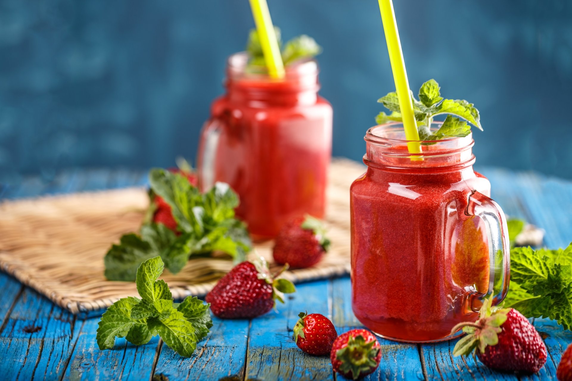 8K Ultra HD PC desktop wallpaper — food still life of strawberry fruit: vibrant berry smoothies in mason jars with fresh strawberries and mint on a blue wooden table.