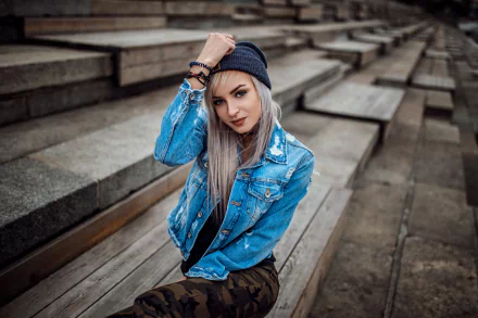 A blonde woman wearing a black hat and denim jacket poses on outdoor wooden steps, captured with a shallow depth of field in this HD PC desktop wallpaper.