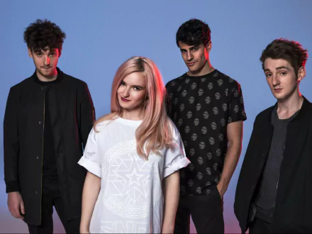 HD wallpaper featuring the music group Clean Bandit, posed against a blue background.