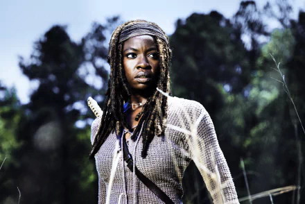 Michonne, portrayed by Danai Gurira in The Walking Dead, stands confidently in a lush background, showcasing her strength and determination in this stunning 4K Ultra HD wallpaper.