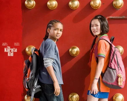 Wenwen Han and Jaden Smith star in a scene from the 2010 film The Karate Kid, set against a vibrant red backdrop, creating a dynamic desktop wallpaper design.