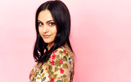 Portrait of American actress Camila Mendes with black hair and brown eyes, against a soft pink background in 4K Ultra HD quality.