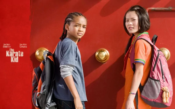 Wenwen Han and Jaden Smith star in a scene from the 2010 film The Karate Kid, set against a vibrant red backdrop, creating a dynamic desktop wallpaper design.