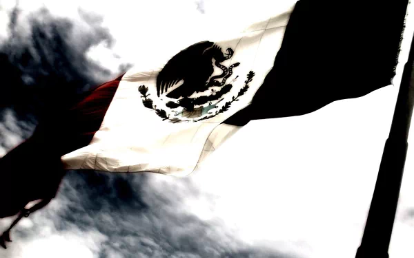 HD desktop wallpaper featuring the Mexican flag waving against a dramatic cloudy sky background.