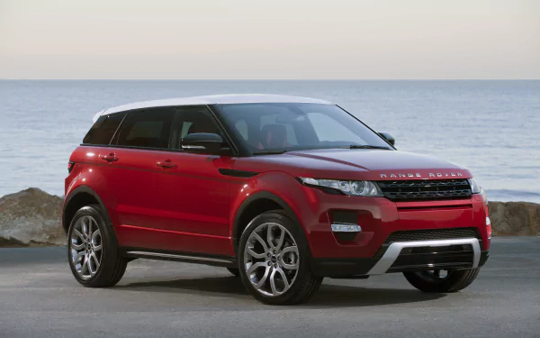 Red Land Rover Range Rover SUV parked by the seaside, presented in 4K Ultra HD for a PC desktop wallpaper and background.