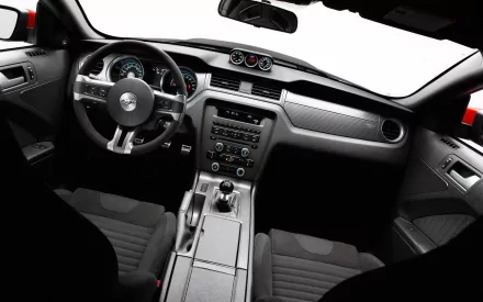 Interior view of a Ford Mustang Boss 302, showcasing its sleek dashboard, controls, and sporty design. A high-definition desktop wallpaper for car enthusiasts.