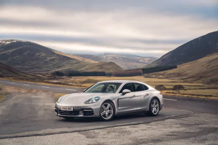 Silver Porsche Panamera 4S parked on a mountain road under cloudy skies, captured in stunning 4K Ultra HD for a PC desktop background.