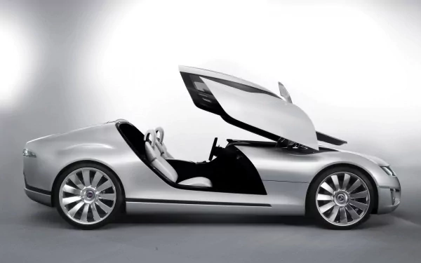 HD PC desktop wallpaper: silver Saab concept car (vehicle) with gullwing doors open, sleek low-slung sports profile on a neutral gray background.