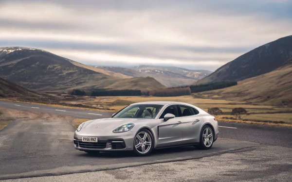 Silver Porsche Panamera 4S parked on a mountain road under cloudy skies, captured in stunning 4K Ultra HD for a PC desktop background.