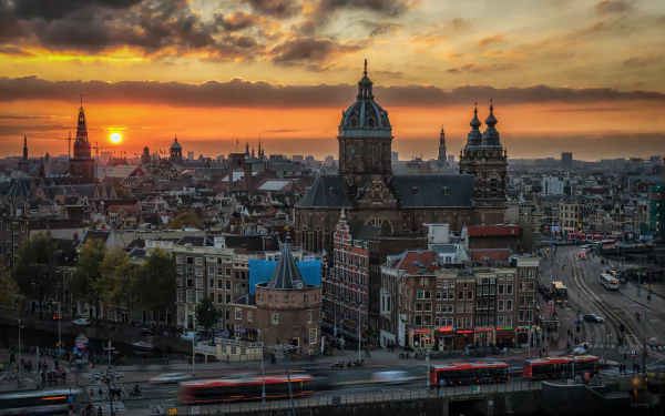 HD desktop wallpaper showcasing Amsterdam’s cityscape at sunset, featuring historic buildings and vibrant skies in the Netherlands.